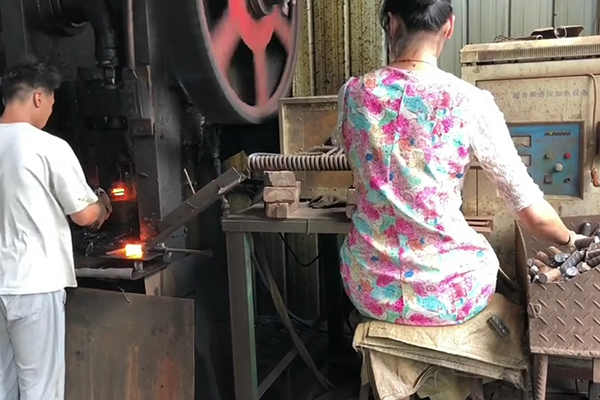 螺纹钢筋通过超音频HULUWA葫芦娃下载入口安卓加热设备加热后 冲床锻压成螺母坯型